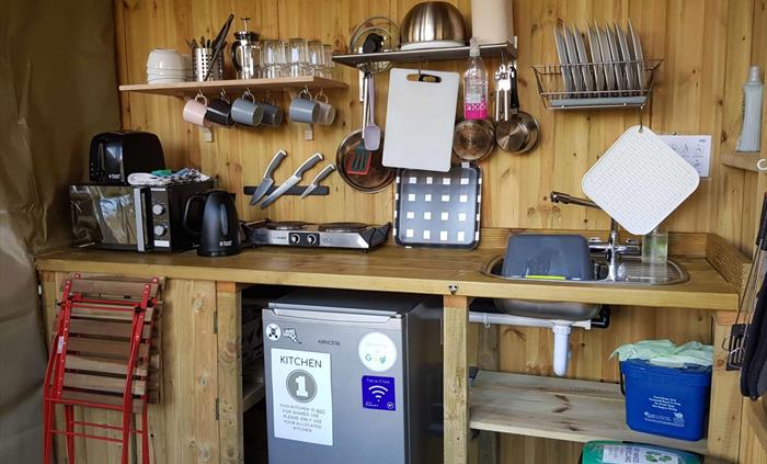 a wooden camping kitchen with fridge microwave hob kettle toaster equipment crockery
